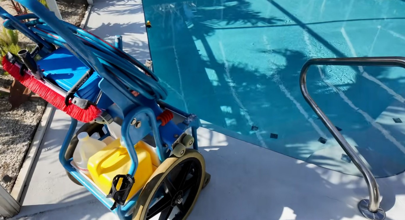 Professional pool cleaning equipment including brush and skimmer ready for pool maintenance in Leesburg, FL